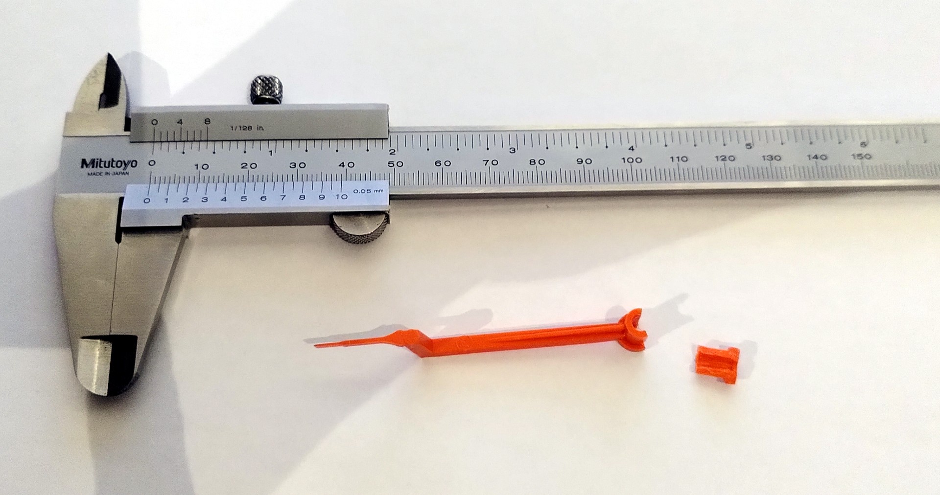 Broken pointer with Vernier calipers for size.